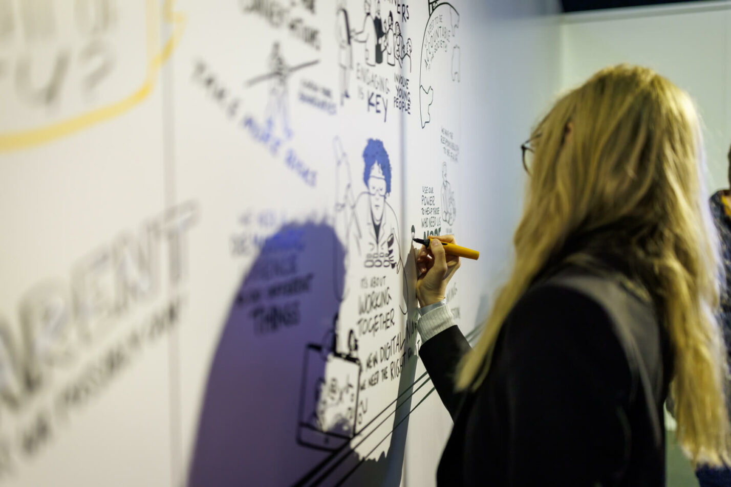 Live graphic recording at a business workshop with real-time illustration on a large board.
