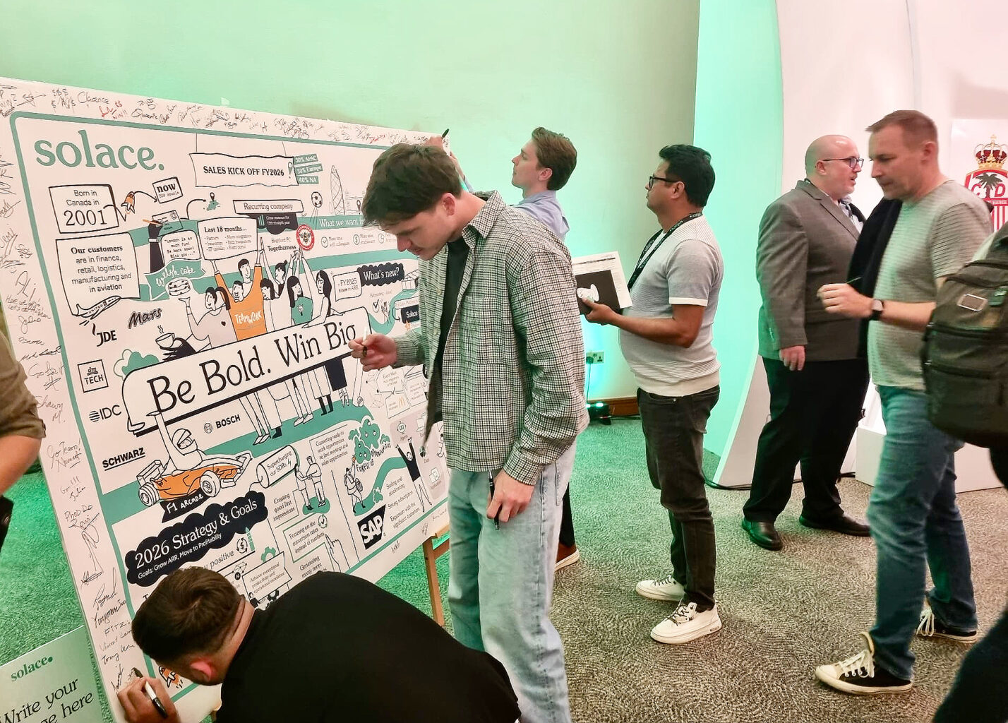 Attendees engaging with a live scribing visual summary at a strategy event.
