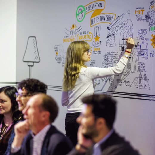 Live scribe hand-drawing event illustration on wall in front of audience